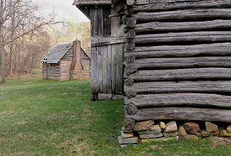 Photo by Patti Black a log cabin and a log cabin in a field